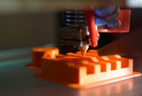 3d Printing - a close up of an orange object with a pencil