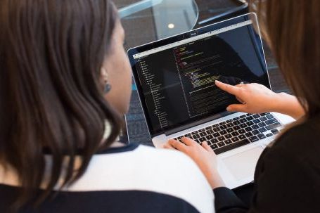 Pair Programming - Two Women Looking at the Code at Laptop